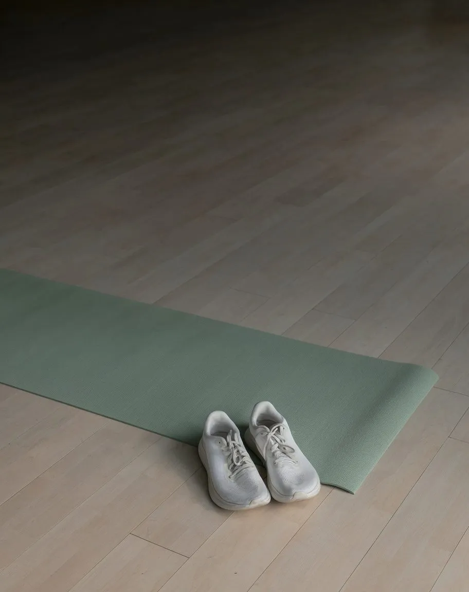 Yoga mat and running shoes in morning light
